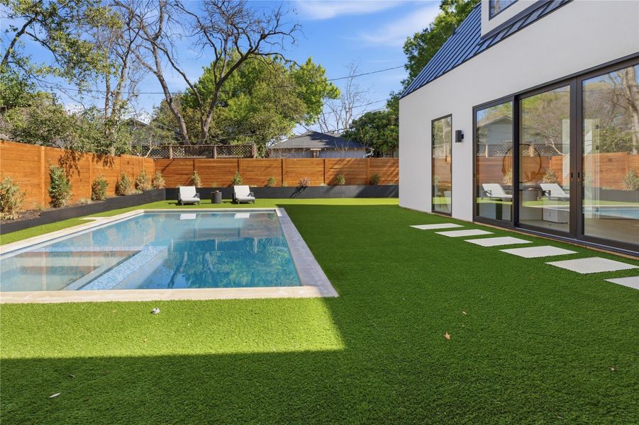 Combined pool / hot tub featuring a fenced backyard and a patio area