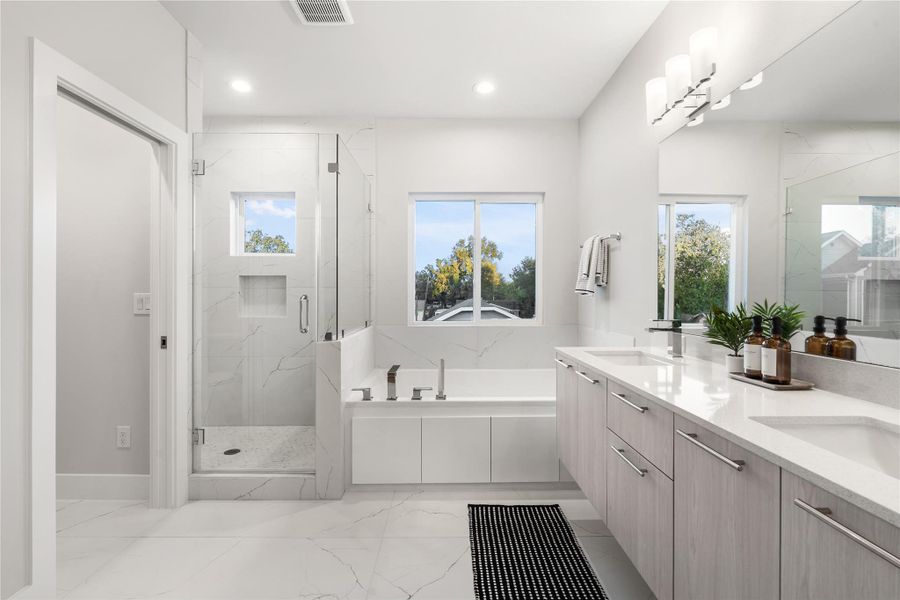 The primary ensuite feels bright and airy, featuring custom windows that fill the space with natural light and highlight the sleek, modern finishes throughout. The primary ensuite feels bright and airy, featuring custom windows that fill the space with natural light and highlight the sleek, modern finishes throughout.