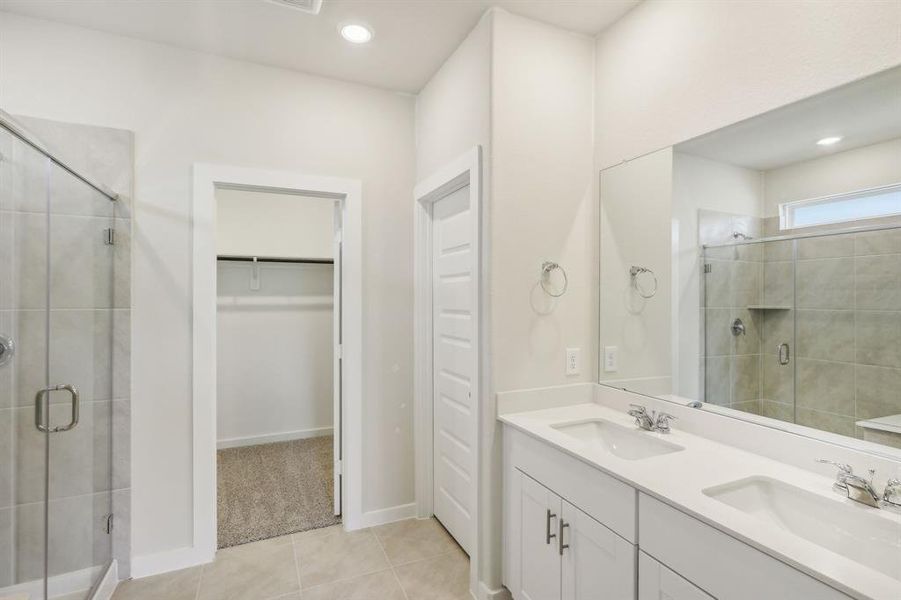 Primary bath has dual vanities and big standing shower