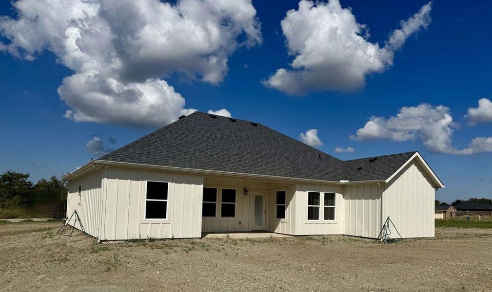 Rear view of house featuring a shingled roof, a patio area, and board and batten siding Rear view of house featuring a shingled roof, a patio area, and board and batten siding