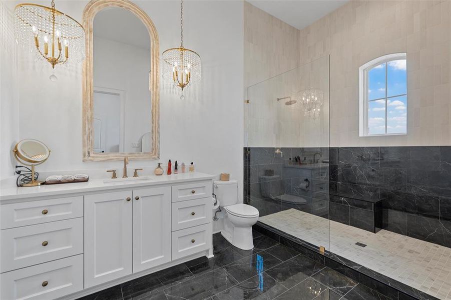 Full bathroom featuring vanity, a walk in shower, a chandelier, and dark marble finish flooring