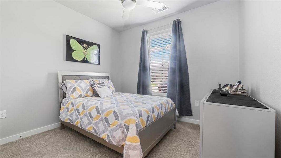 Bedroom featuring light carpet and ceiling fan