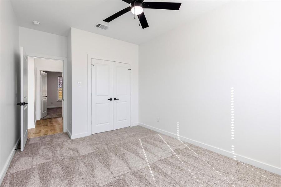 Unfurnished bedroom with baseboards, visible vents, ceiling fan, a closet, and carpet flooring