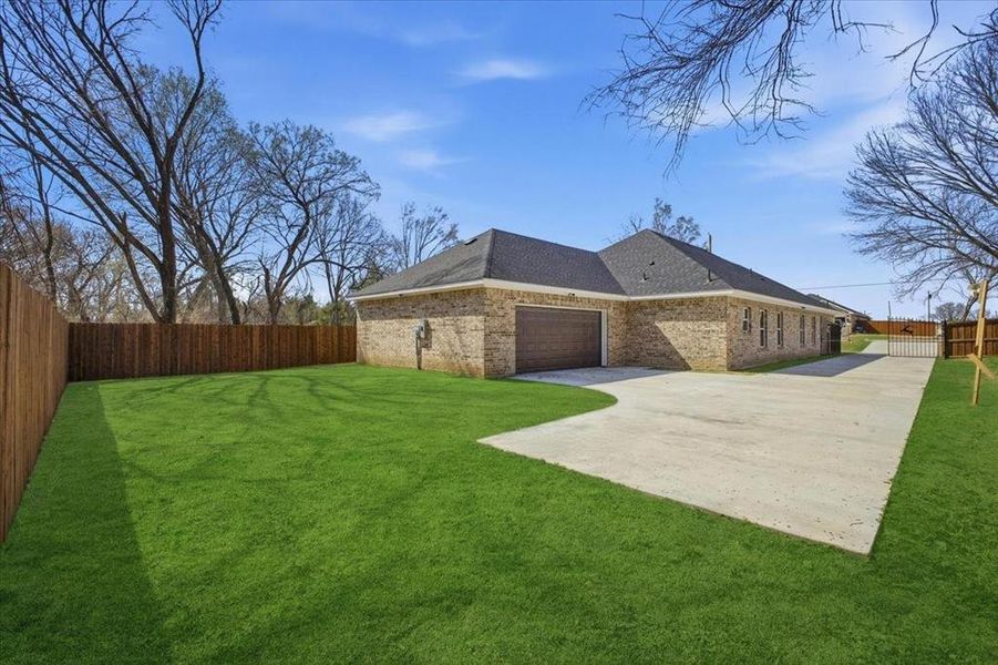 View of side of property featuring an attached garage, roof with shingles, brick siding, and concrete driveway