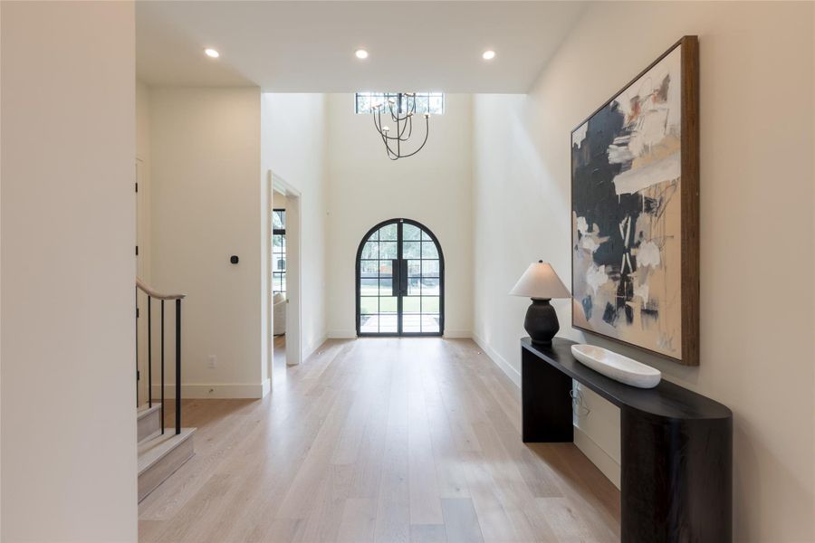 Anchored by a custom-made iron arched front door, the entryway sets the tone with soaring ceilings, European white oak floors, and a Kelly Wearstler alabaster chandelier that casts an elegant glow. Every detail is intentional—where soft curves, natural textures, and refined materials welcome you into the heart of the home. Anchored by a custom-made iron arched front door, the entryway sets the tone with soaring ceilings, European white oak floors, and a Kelly Wearstler alabaster chandelier that casts an elegant glow. Every detail is intentional—where soft curves, natural textures, and refined materials welcome you into the heart of the home.