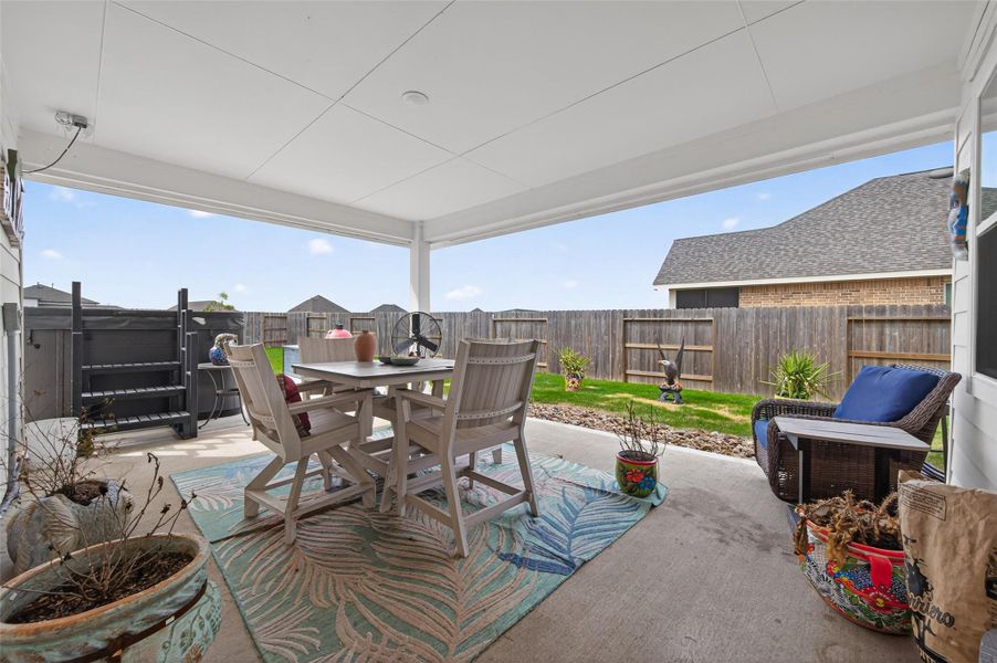 Backyard covered patio with views of the fenced yard