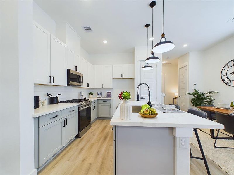 This attractive kitchen is full of beautiful details. Quartz countertops, stainless steel sink, stainless steel appliances, recessed lighting, undercabinet lighting, pantry, elegant cabinetry with soft close drawers and doors. Photos from another development by Disama Building Group. FINISHES & COLORS MAY VARY.