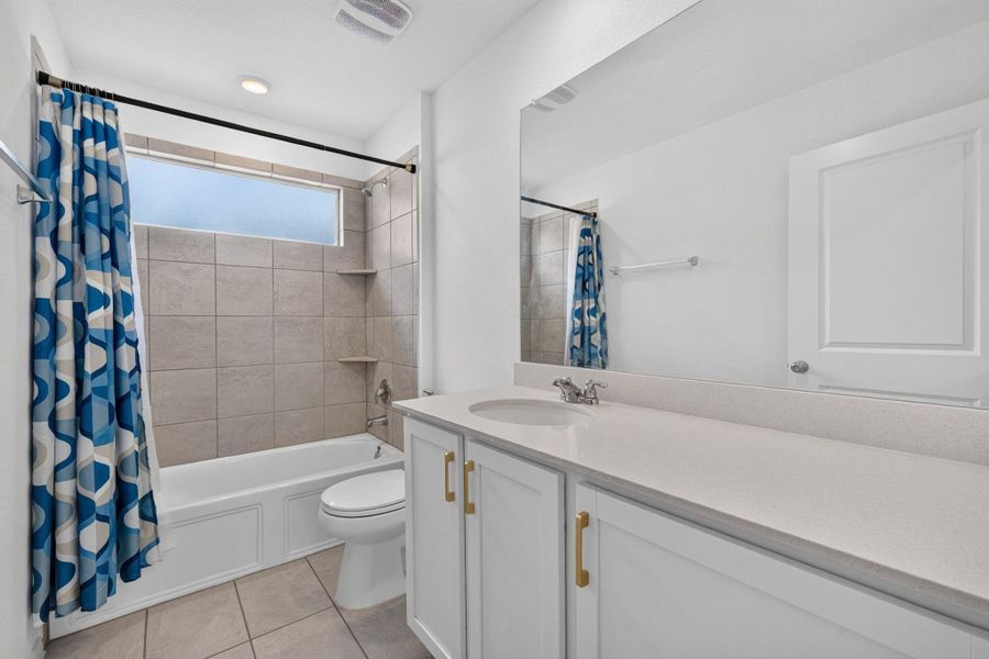 A well-appointed bathroom features a single vanity, a combination tub and shower, and tiled flooring. A well-appointed bathroom features a single vanity, a combination tub and shower, and tiled flooring.
