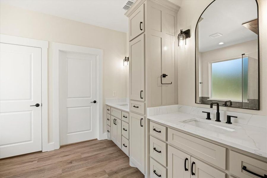 Full bathroom with two vanities and light wood-style floors
