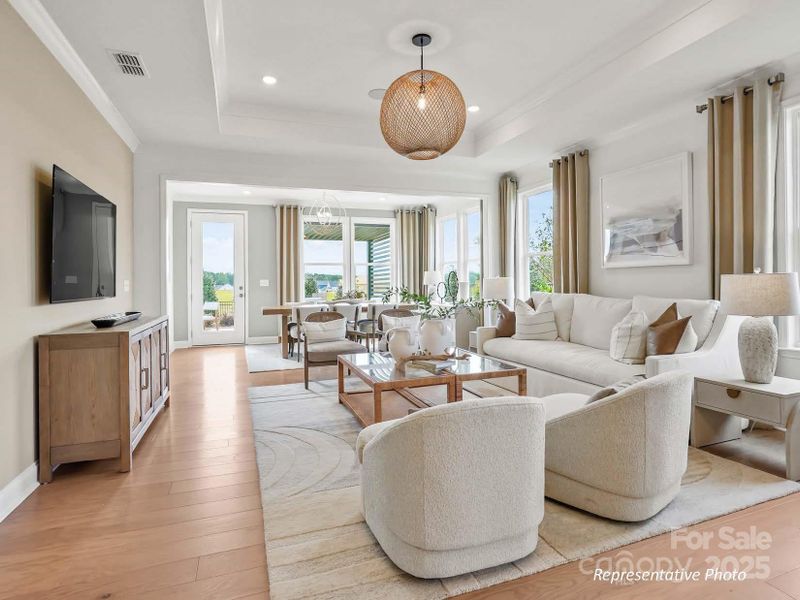 Gathering room features a tray ceiling, crown molding, and ample natural light.