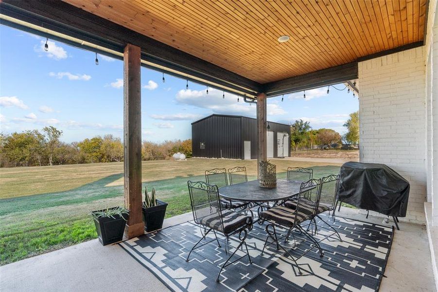 View of patio with a grill