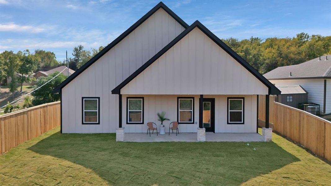 Back of property with board and batten siding, a fenced backyard, and a patio area Back of property with board and batten siding, a fenced backyard, and a patio area