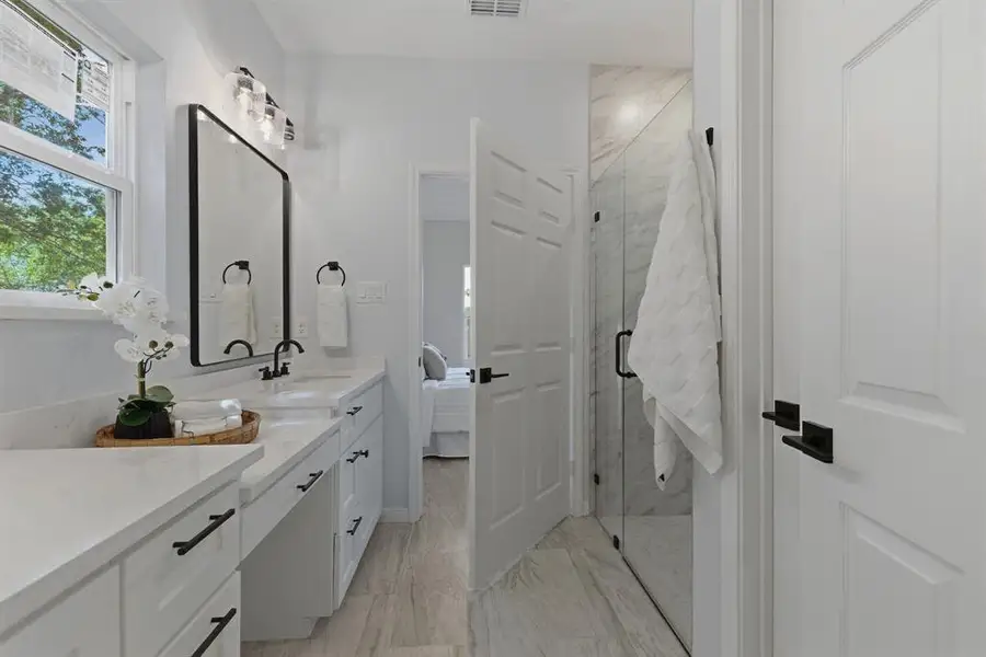 Bathroom with ensuite bathroom, vanity, and a marble finish shower Bathroom with ensuite bathroom, vanity, and a marble finish shower