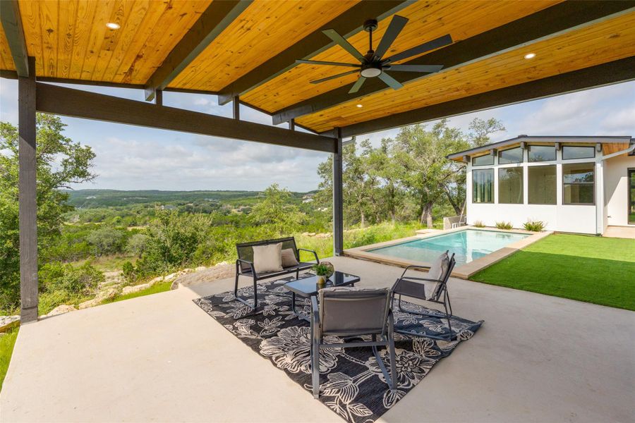An inviting pool beckons, offering refreshing relaxation against a panoramic, tree-lined landscape.