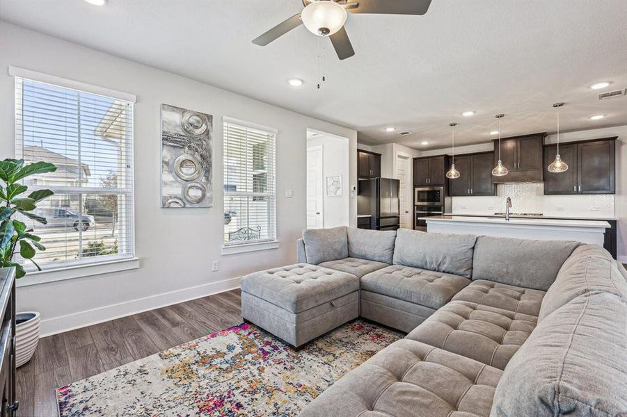 Living room featuring a wealth of natural light, ceiling fan, and light LVP floors