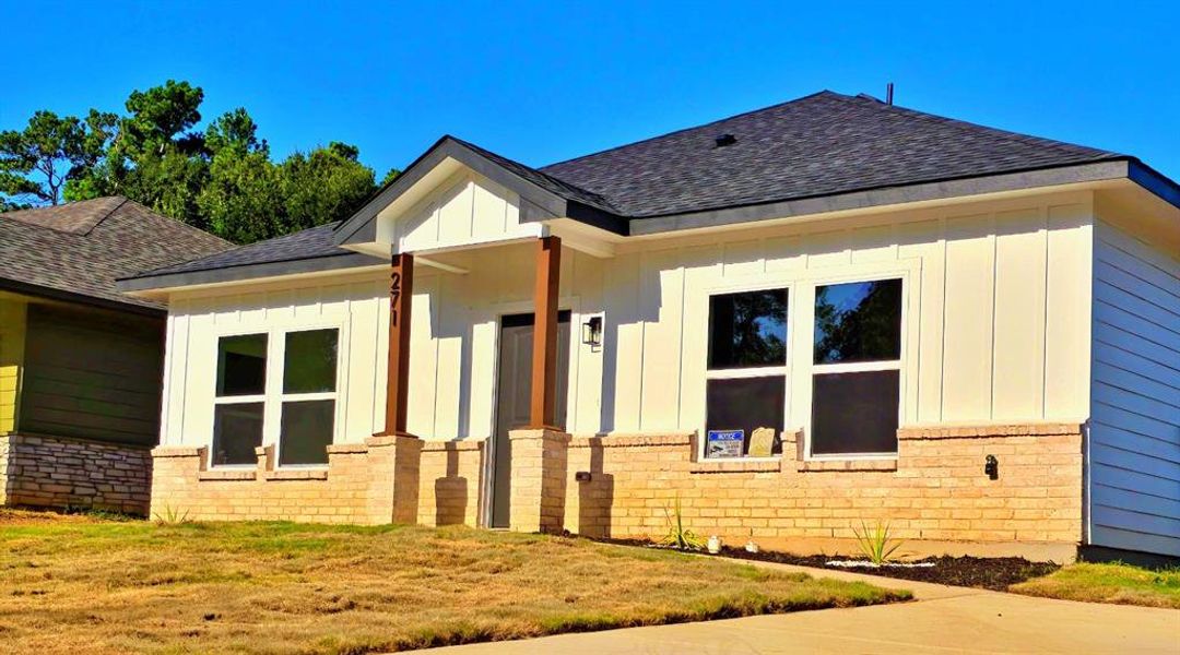 View of side of property featuring board and batten siding, a shingled roof, and brick siding View of side of property featuring board and batten siding, a shingled roof, and brick siding