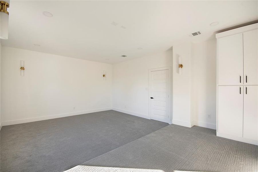 Unfurnished bedroom featuring dark colored carpet and baseboards Unfurnished bedroom featuring dark colored carpet and baseboards