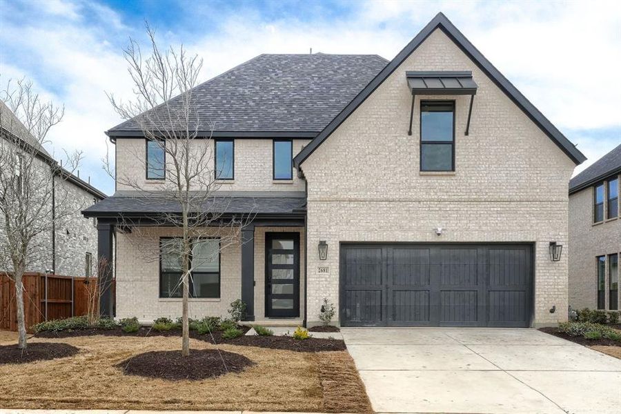 View of front of property with brick siding, driveway, a shingled roof, and a garage