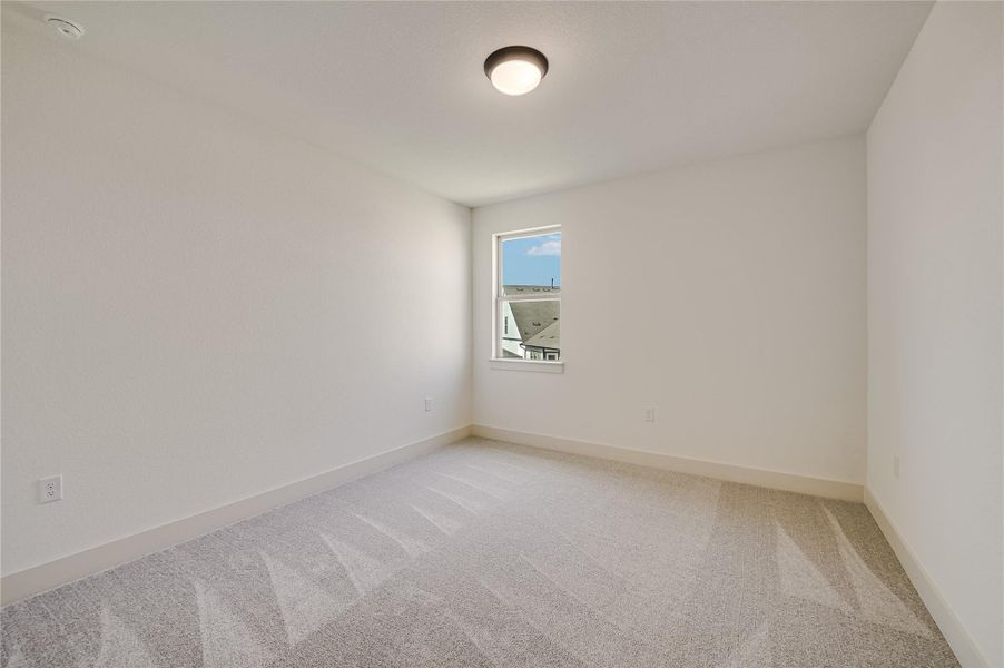 Carpeted spare room with baseboards