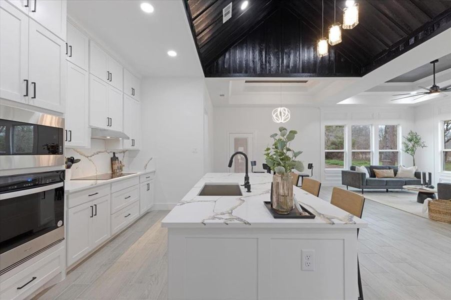 Kitchen featuring a breakfast bar, a center island with sink, and stainless steel appliances