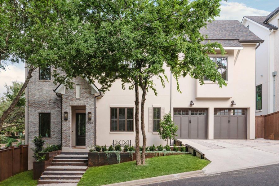 Stucco and brick exterior with steel landscape terracing and double carport doors.