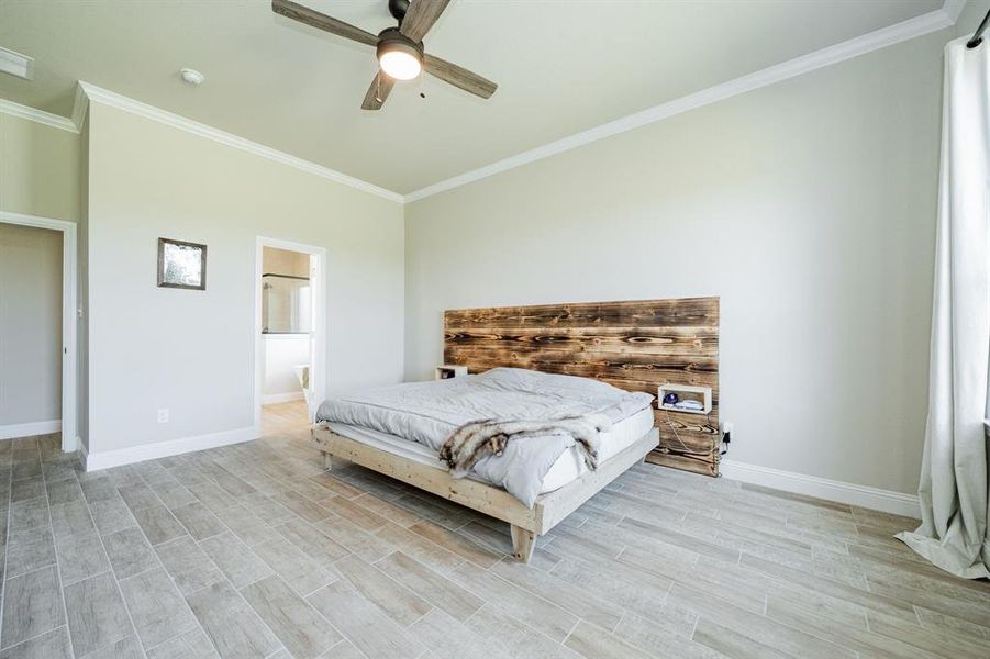 Bedroom with crown molding, wood finish floors, ceiling fan, and ensuite bathroom Bedroom with crown molding, wood finish floors, ceiling fan, and ensuite bathroom