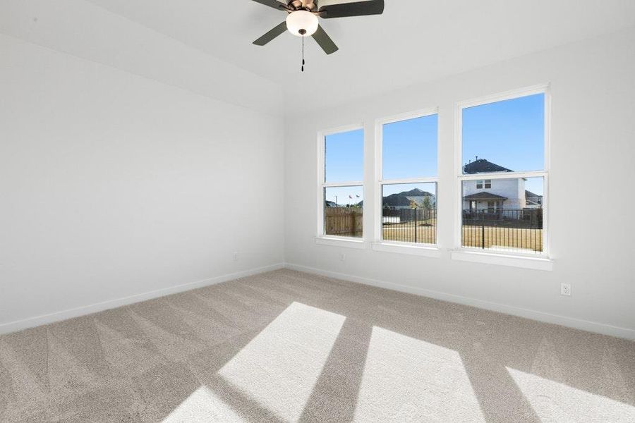 Unfurnished room featuring light carpet and a ceiling fan Unfurnished room featuring light carpet and a ceiling fan