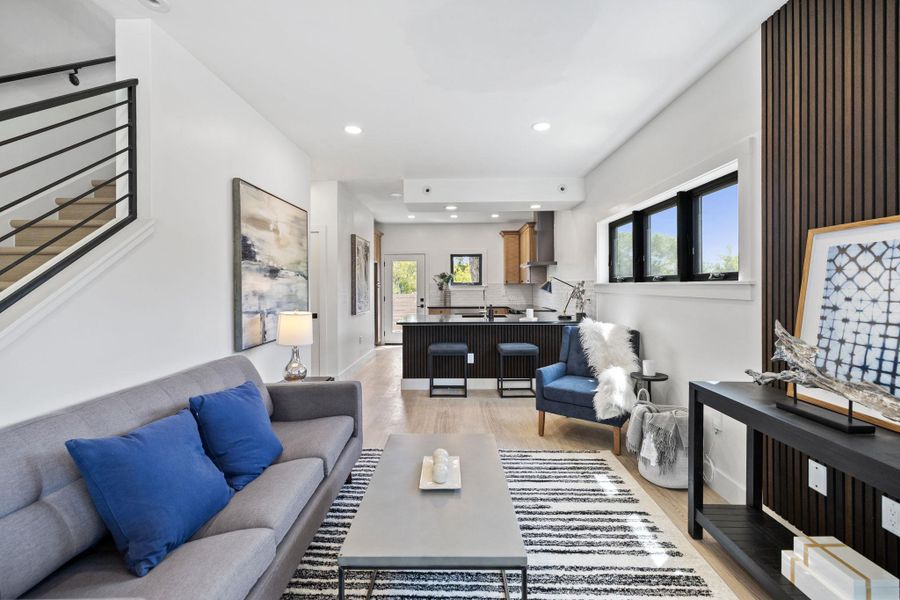 Living area with recessed lighting, stairway, and light wood-style floors