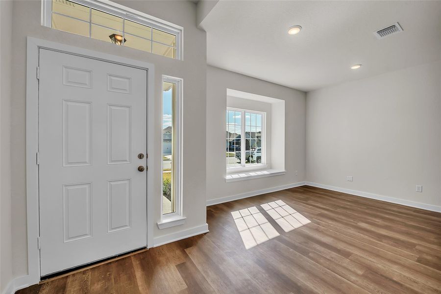 Foyer entrance featuring baseboards and wood finished floors Foyer entrance featuring baseboards and wood finished floors