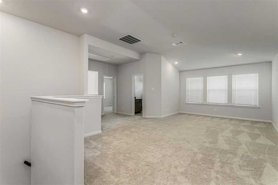 Enjoy the versatility of this expansive living area, perfect for entertaining or family gatherings. The neutral tones, plush carpeting, and recessed lighting create a warm and inviting ambiance, while the large windows flood the space with natural light. Photos are from another Rylan floor plan.