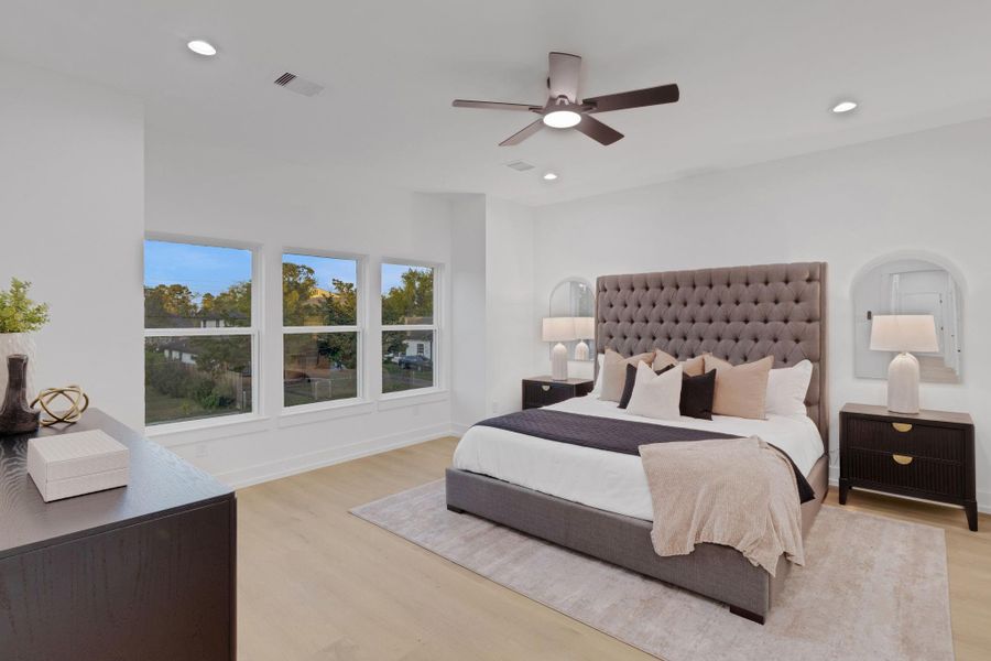 Expansive primary suite with large windows, tray ceiling, and serene views Expansive primary suite with large windows, tray ceiling, and serene views