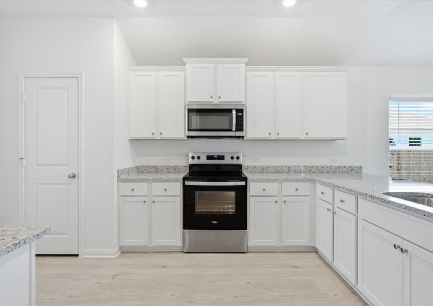 Kitchen featuring a stainless steel range, granite countertops, and white cabinetry. Kitchen featuring a stainless steel range, granite countertops, and white cabinetry.