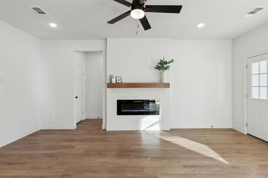 living room featuring a fireplace, hardwood / wood-style floors, and ceiling fan