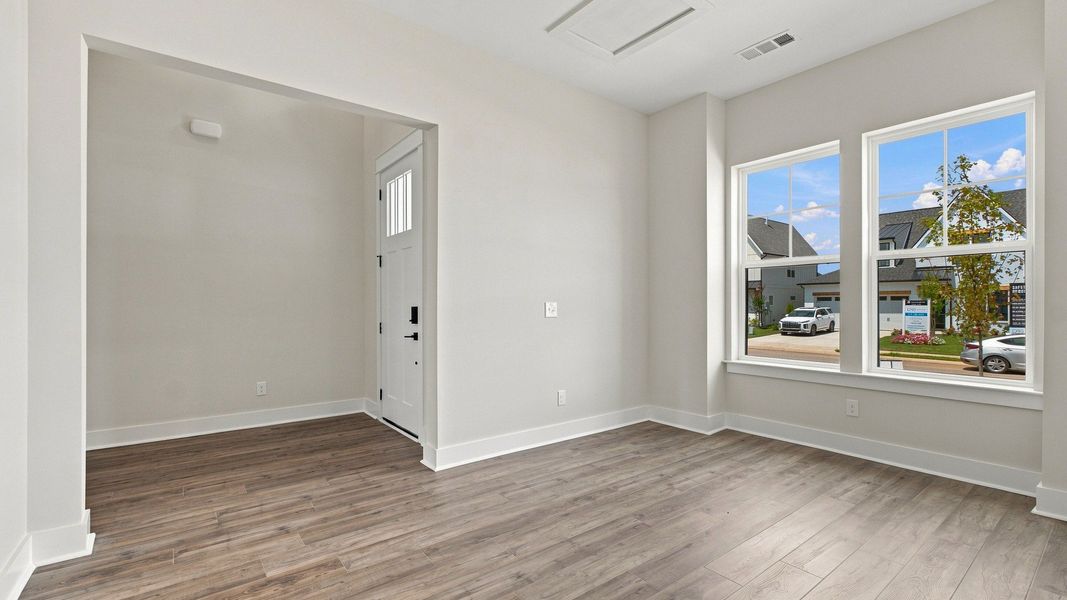 Living space view of front door and neighborhood outlook from two windows.