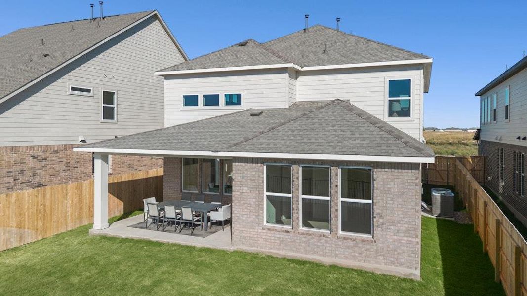 Back of house featuring a shingled roof, a patio area, brick siding, and a fenced backyard Back of house featuring a shingled roof, a patio area, brick siding, and a fenced backyard