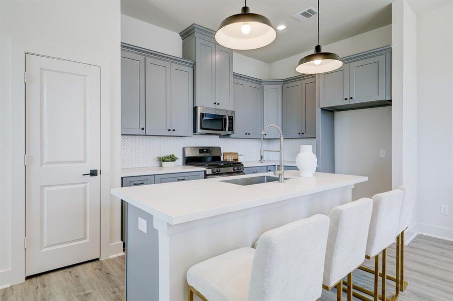 Two stylish light pendants hang overthe kitchen island.