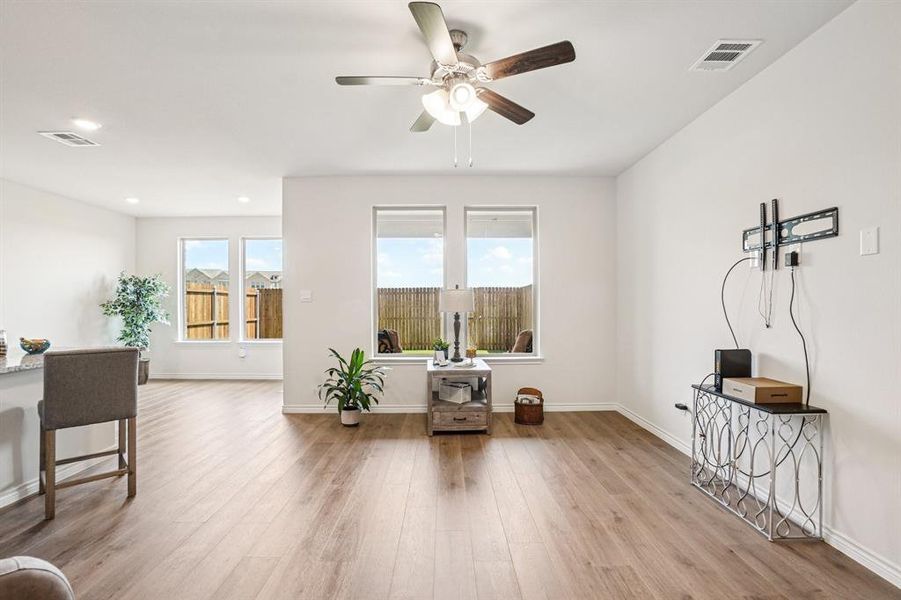 Living area with light wood-style flooring, plenty of natural light, a ceiling fan, and recessed lighting Living area with light wood-style flooring, plenty of natural light, a ceiling fan, and recessed lighting