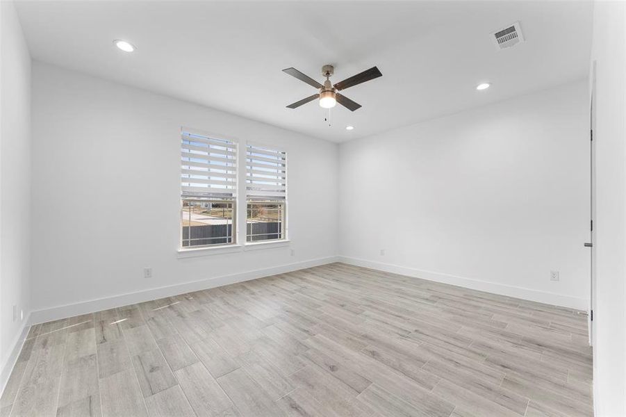 Empty room featuring light wood-type flooring and ceiling fan