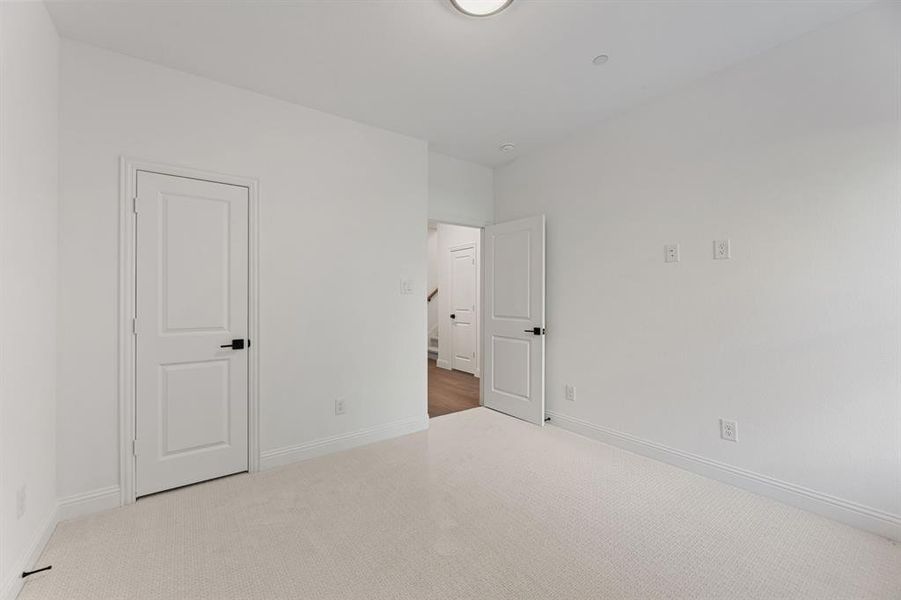 Unfurnished bedroom with carpet flooring and baseboards Unfurnished bedroom with carpet flooring and baseboards