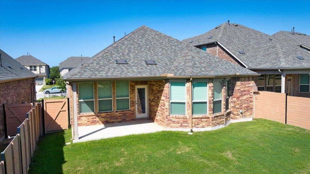 A neatly manicured lawn embraces the brick exterior and private patio of this residence.