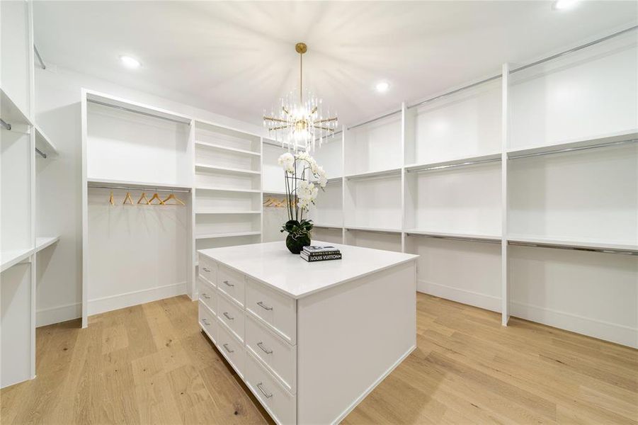 Walk in closet featuring light wood finished floors and hanging lights