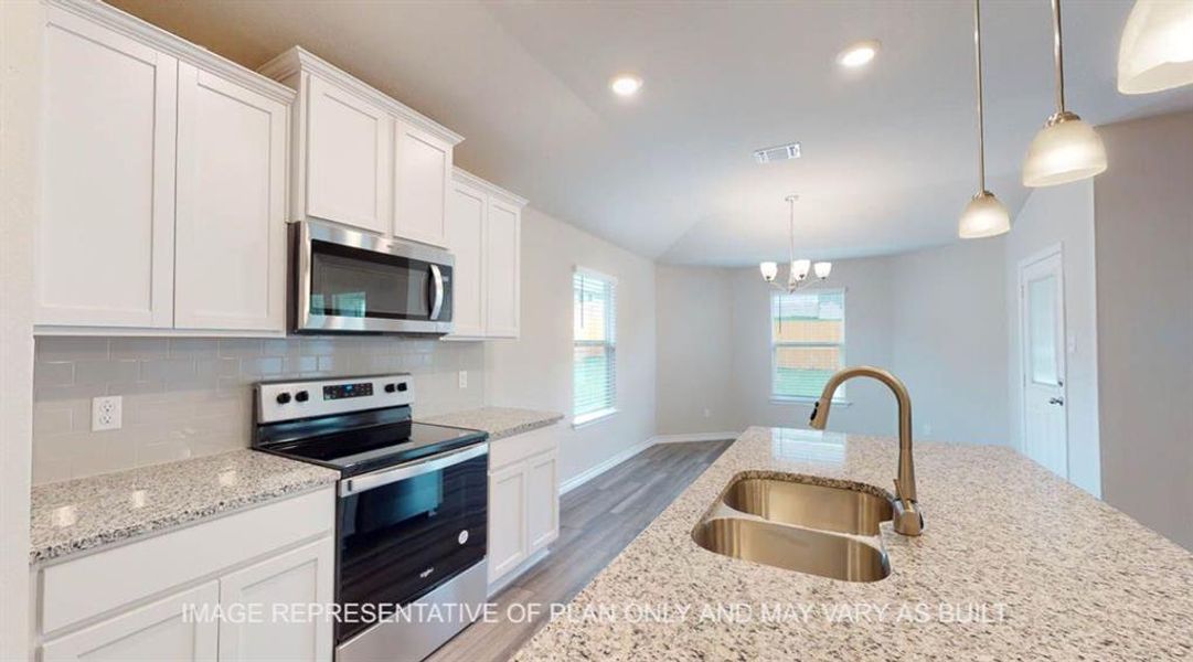 Kitchen with appliances with stainless steel finishes, decorative light fixtures, white cabinetry, tasteful backsplash, and light wood-style flooring Kitchen with appliances with stainless steel finishes, decorative light fixtures, white cabinetry, tasteful backsplash, and light wood-style flooring