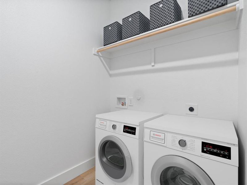 Laundry area featuring laundry area, light wood finished floors, baseboards, and separate washer and dryer