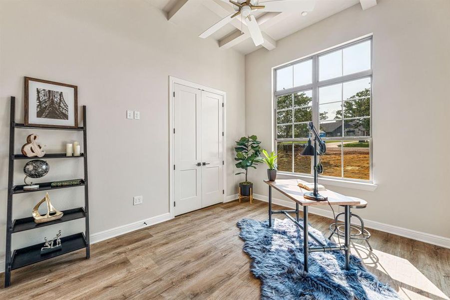 Home office with beamed ceiling, ceiling fan, and light wood-type flooring