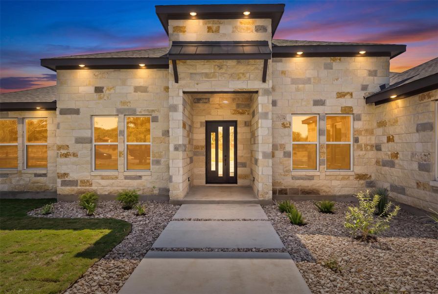 A striking stone facade with a modern entry and accent lighting sets the tone for elegant living. A striking stone facade with a modern entry and accent lighting sets the tone for elegant living.