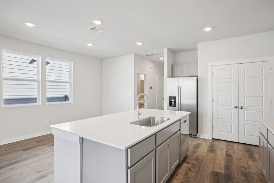 A kitchen with white cabinets.
