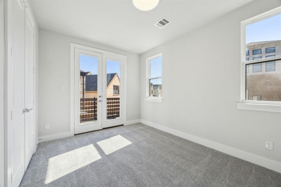 secondary bedroom featuring french doors and a healthy amount of sunlight