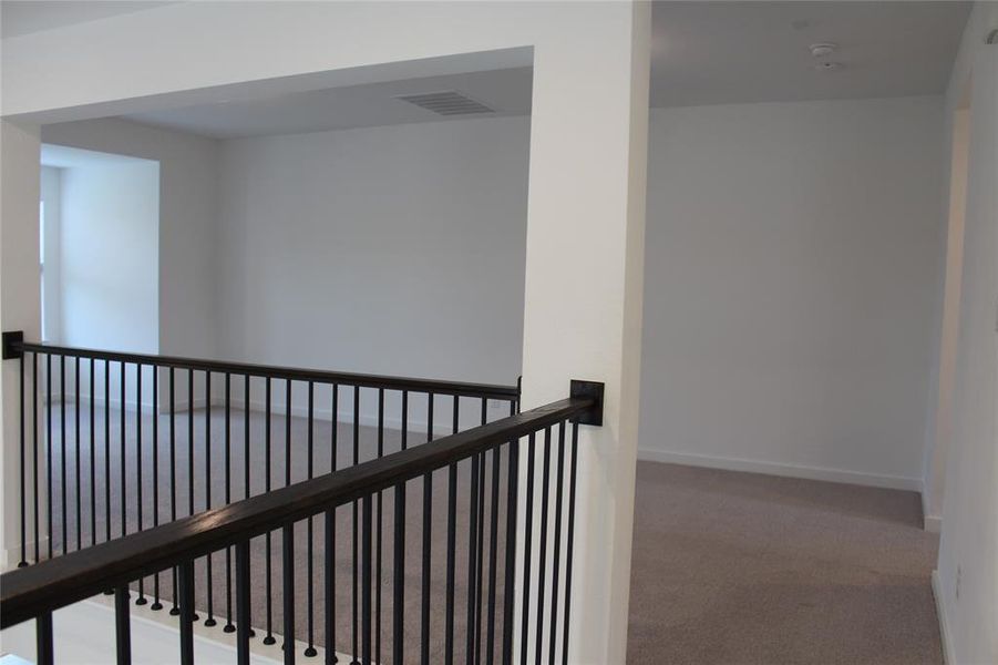 Hall with an upstairs landing and carpet floors