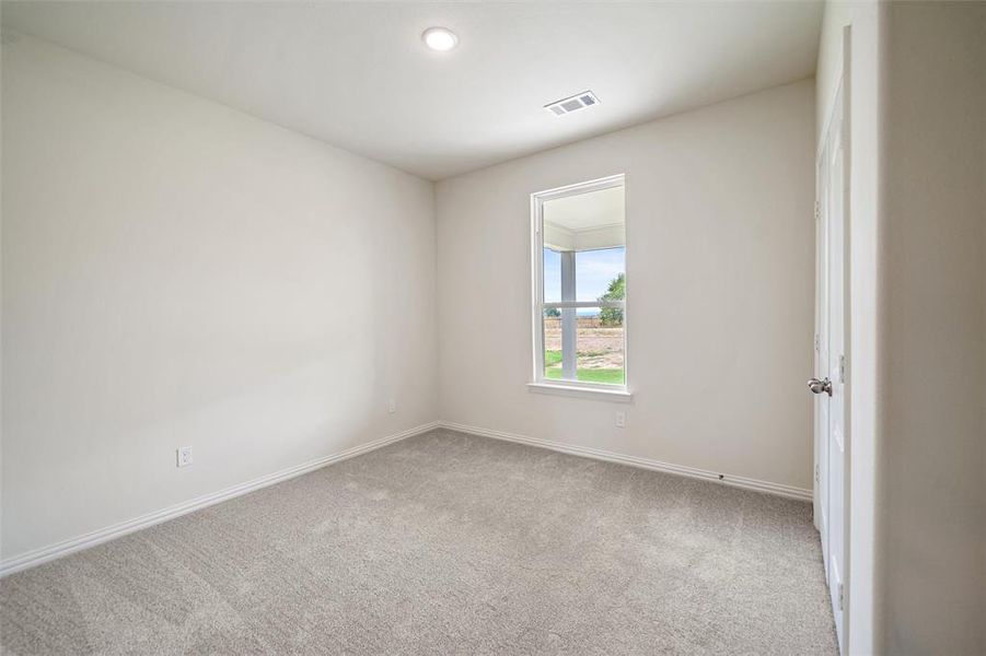 Spare room featuring light colored carpet and baseboards