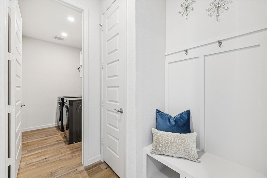 The property includes a dedicated laundry area with wood-look tile flooring and recessed lighting